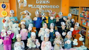 Dzieci pozują do zdjęcia grupowego z misiami i medalami