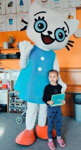 Dziewczynka pozuje z Kicią Kocią