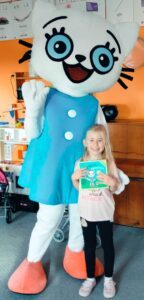 Dziewczynka pozuje z Kicią Kocią