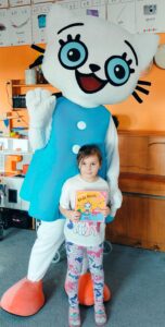 Dziewczynka pozuje z Kicią Kocią