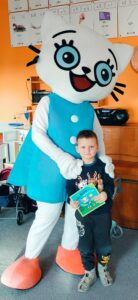 Chłopiec pozuje z Kicią Kocią