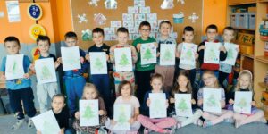 Zdjęcie grupowe z narysowanymi przez dzieci choinkami