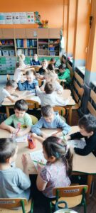 Dzieci uzupełniają karty przy stolikach