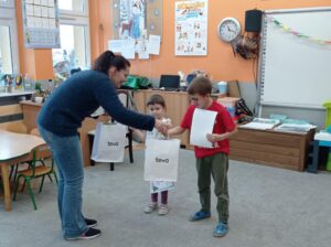 nauczycielka wręcza dyplomy