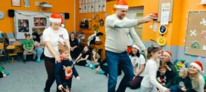 dzieci w opaskach reniferów prowadzą rodziców