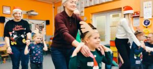 dzieci w opaskach reniferów prowadzą rodziców