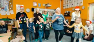 dzieci w opaskach reniferów prowadzą rodziców