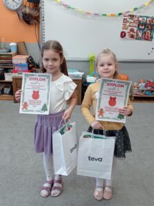 dwie dziewczynki pokazują dyplomy
